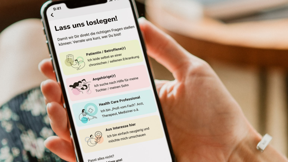 Zwei Frauenhände halten ein Handy. Darauf ist die App unrere.me zu sehen.